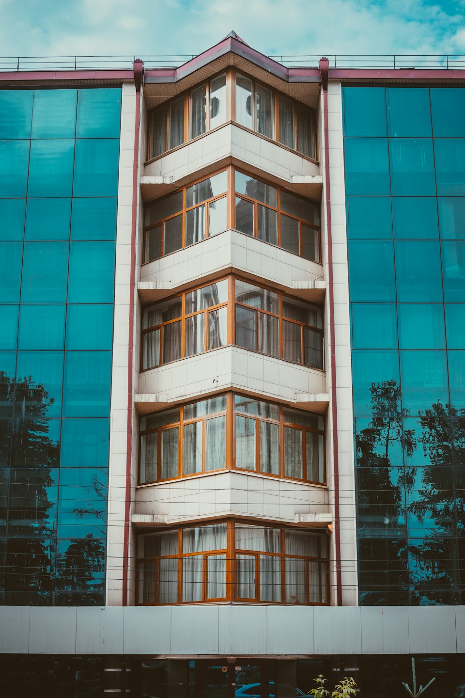 Modern building with wooden framed windows and blue glass panels.