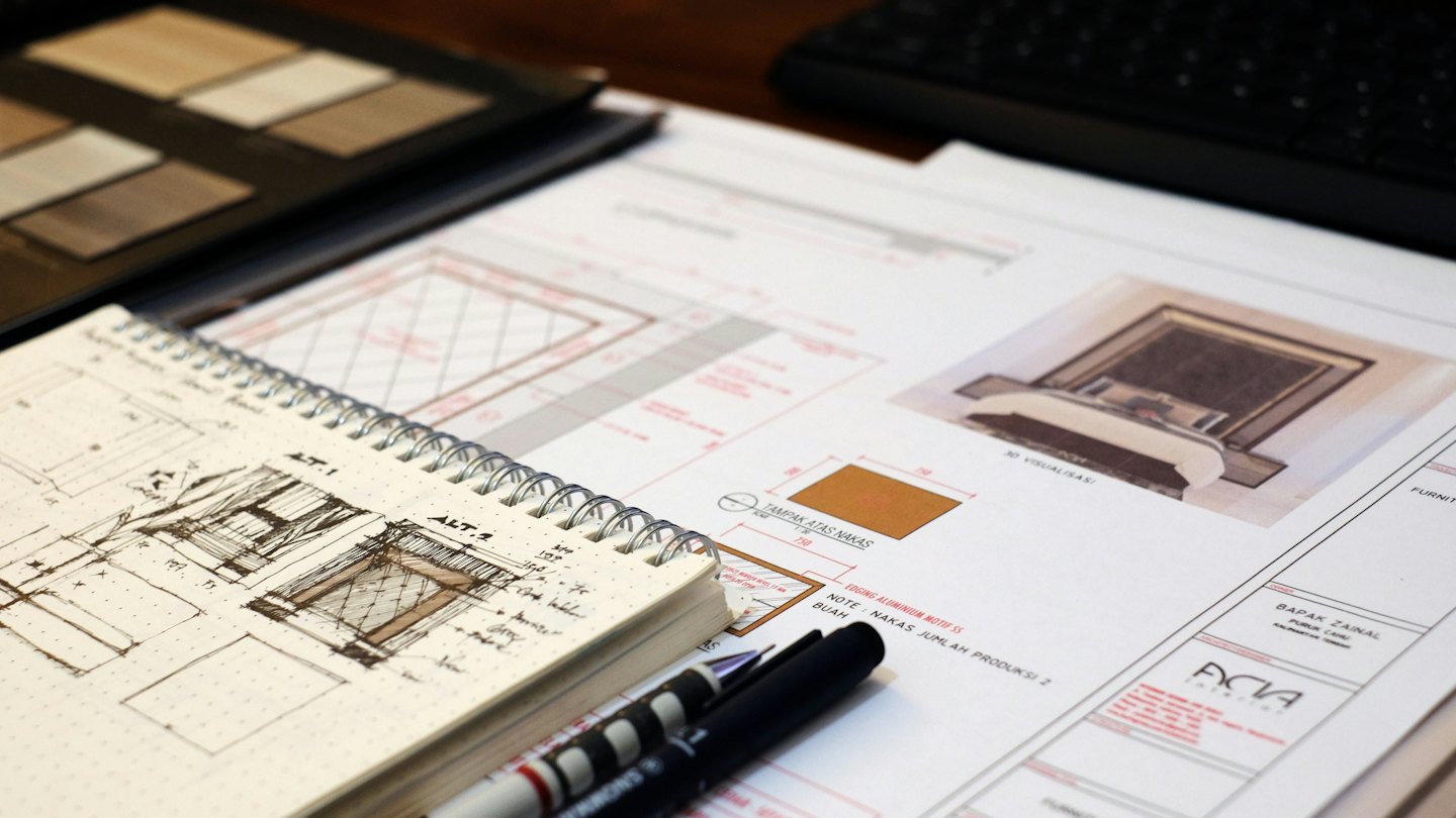 Architectural plans and sketches on a wooden desk.