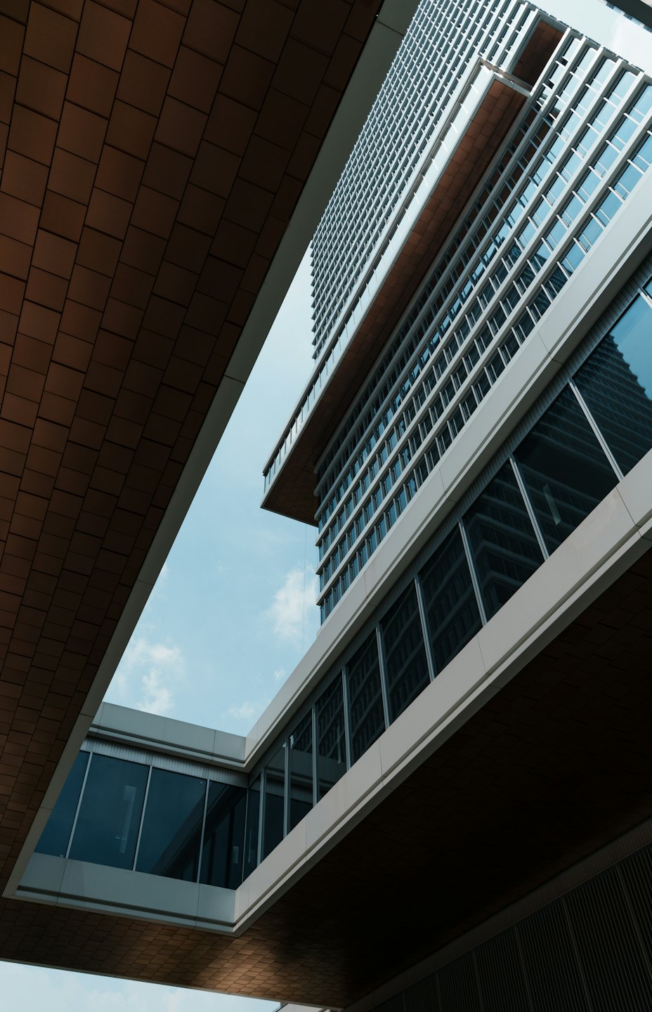 Modern office building exterior with glass facades against a blue sky.