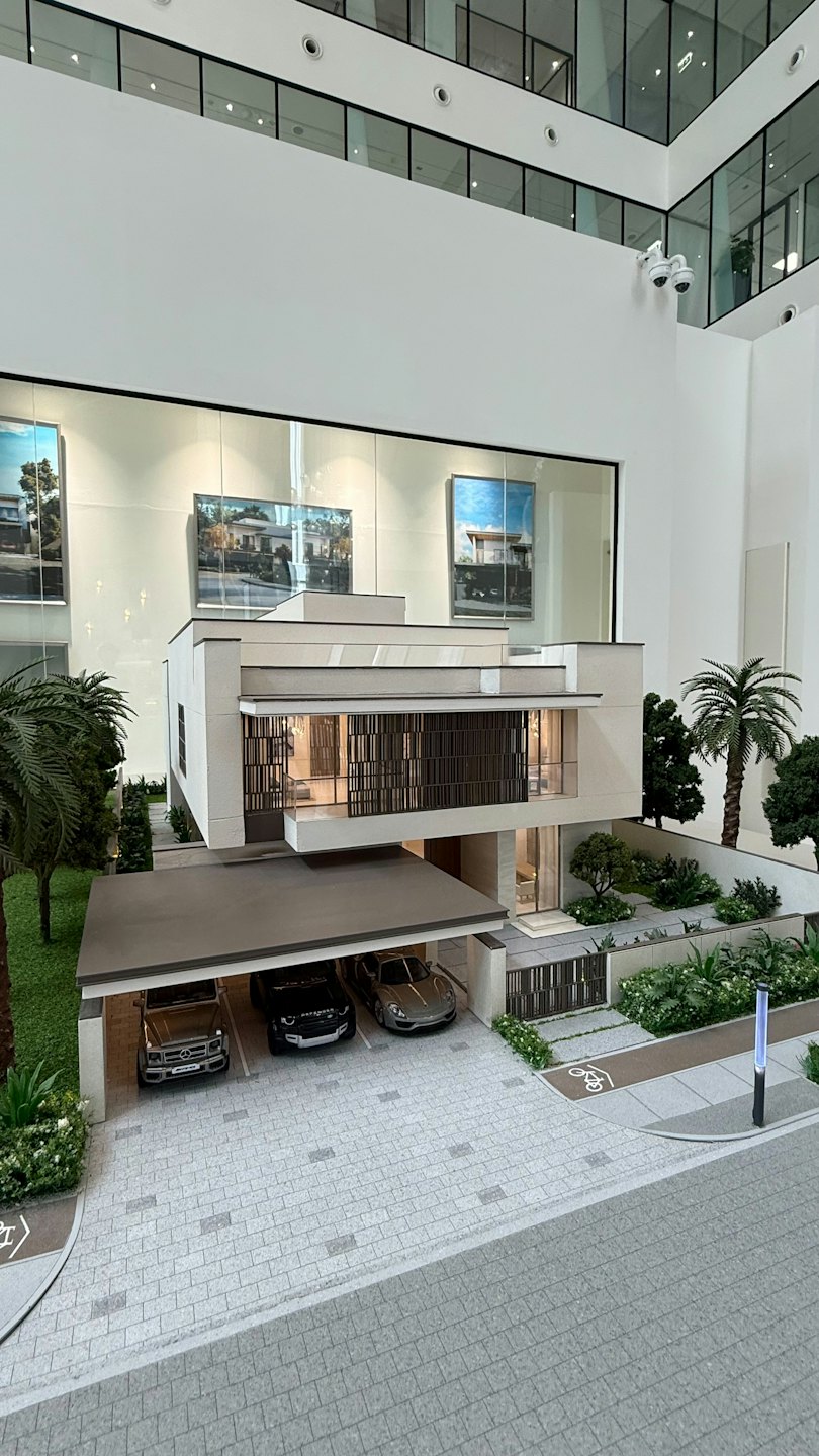 Architectural model of a modern multi-story house with landscaping.